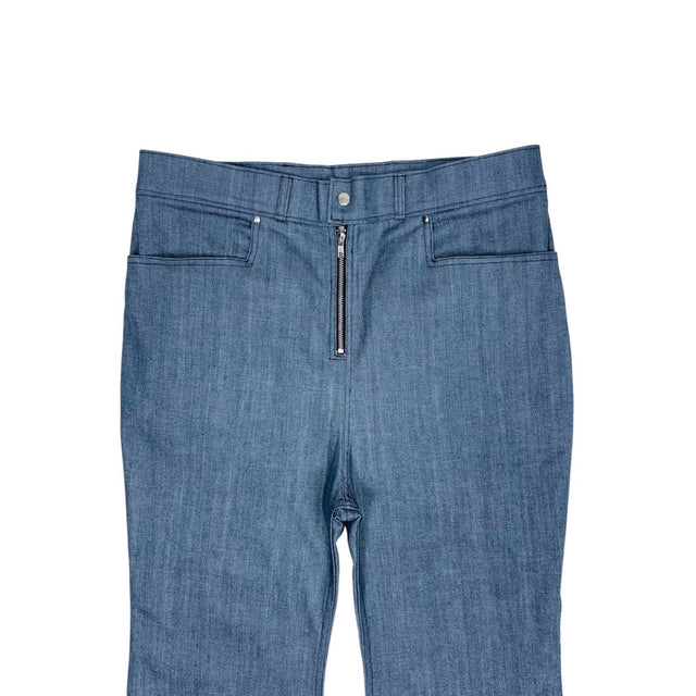 Close-up of the front of the LOVANT blue UNIFORM flared denim, showing the button waistband, exposed zip fly and riveted pockets.