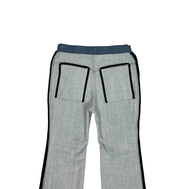 Close-up of the inside back of the LOVANT blue UNIFORM flared denim, showing the black bound pocket edges against the light denim.