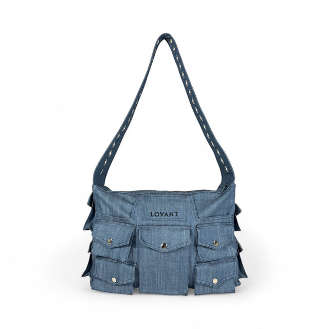 Front view of the LOVANT Azul utility cargo bag in blue denim, showing the LOVANT embroidered patch and rows of snap-flap cargo pockets.