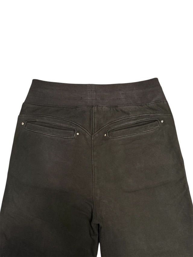 Close-up of the back of the LOVANT black sweats, showing the ribbed waistband, curved yoke seam and riveted back welt pockets.