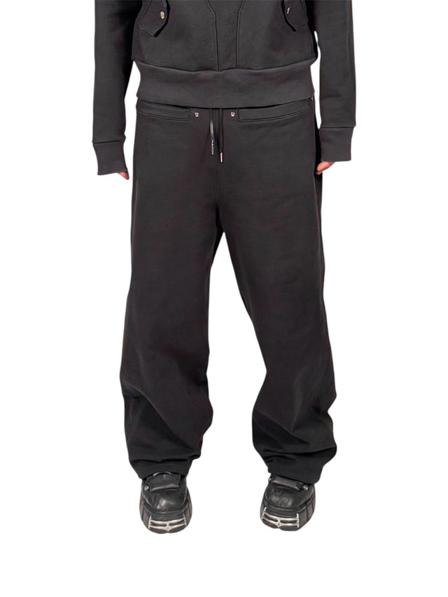 Model wearing the LOVANT black sweats with the black LOVANT raglan hoodie and chunky black boots, photographed from the front.